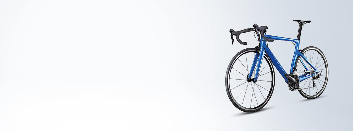 Blaues Rennrad mit schwarzem Lenker und Sattel vor hellgrauem Hintergrund. Das Fahrrad ist so positioniert, dass das Vorderrad leicht zum Betrachter gedreht ist.